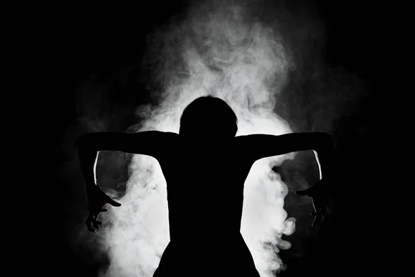 シルエットモダンバレエダンサー煙で暗い背景にポーズ — ストック写真
