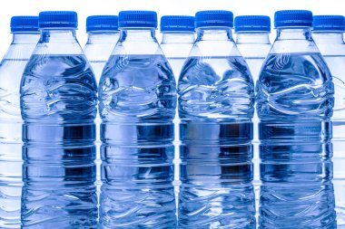 Mavi kapaklı yarım litre plastik su şişesi yığını.