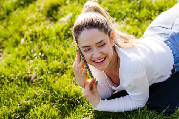 Gyönyörű Lány Fekszik Egy Mezőn Parkban Telefonon Beszél — Stock Fotó