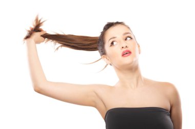 Güzel kız, beyaz arka planda stüdyo fotoğrafına çok yakın. Havada saç tutmak..