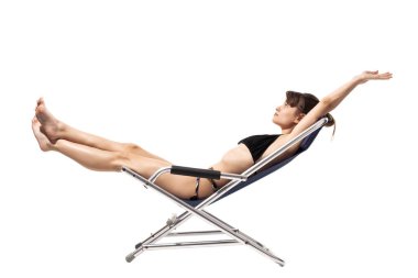 Bembeyaz arka planda, kumsaldaki iskemlede dinlenen mayolu güzel bir genç kız. Yaz konsepti.