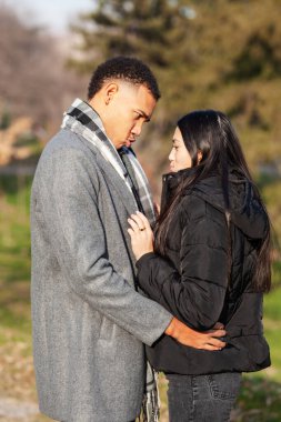 Parkta poz veren kadın ve erkek. Birbirine aşık çok ırklı bir çift..