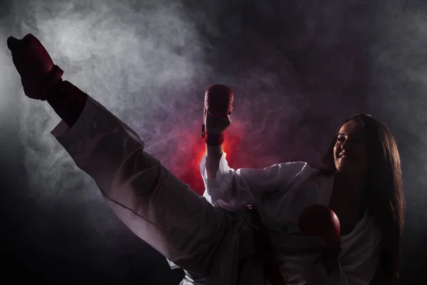 Dziewczyna Ćwiczenia Karate Nogi Kick Przed Czerwonym Tle Mgły — Zdjęcie stockowe