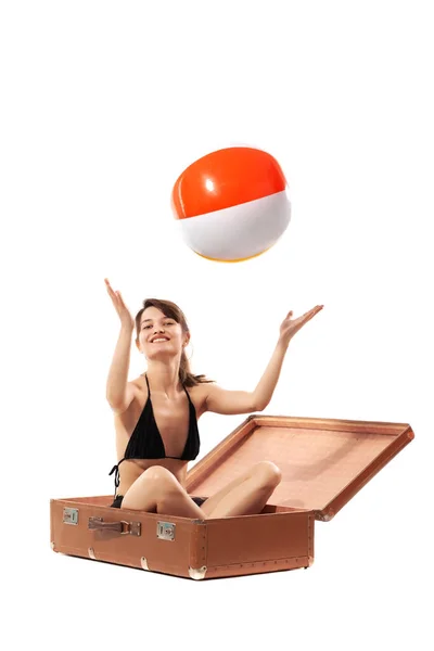 白い背景に隔離されたカラフルなインフレータブルビーチボールで遊んで大きなヴィンテージスーツケースで幸せな女の子 夏の旅行のコンセプト — ストック写真