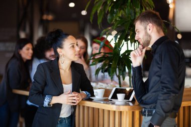 Bir kafede kahve içip sohbet eden arkadaşlar. Başarılı gençler.