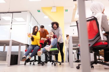 İş arkadaşları iş yerinde eğleniyorlardı. Tekerlekli sandalyedeki erkekleri iten kızlar. Çok ırklı başarılı bir şirket kurma grubu