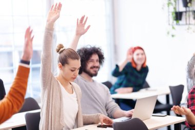 Sınıfta bir öğretim üyesini dinleyen çok ırklı öğrenciler. Sınıfta el pençe divan duran zeki gençler..