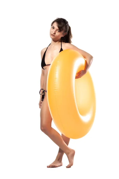 身穿黑色泳衣的年轻貌美的性感女子手持橙色充气橡胶圈 与白色背景隔离 避暑池海景概念 — 图库照片