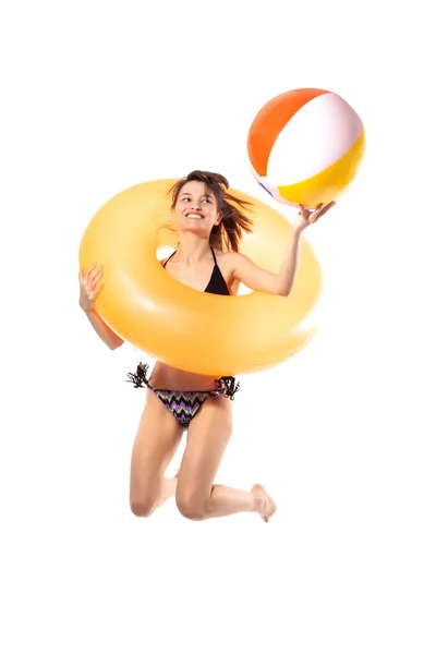 身穿黑色泳衣的年轻貌美的性感女子带着橙色充气橡胶圈和白色背景的球跳了起来 避暑池海景概念 — 图库照片