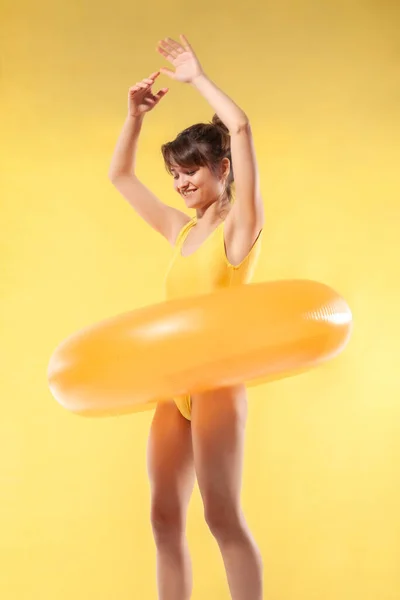 漂亮的年轻性感女孩穿着黄色的一件泳衣玩充气橡胶管 暑假的概念 — 图库照片