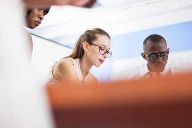 Ofisteki yönetim kurulu masasında birlikte çalışan çok ırklı iş adamları. Beyin fırtınası yapan başarılı bir iş arkadaşı takımı..