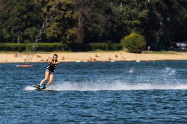 Dişi wakeboardcu uyanıyor. Su kayağı yapan bir kız. Çekici ipi tutuyorum. Gölde yaz aktiviteleri.