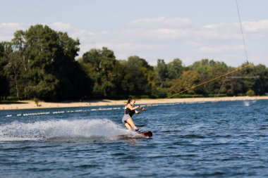 Dişi wakeboardcu uyanıyor. Su kayağı yapan bir kız. Çekici ipi tutuyorum. Gölde yaz aktiviteleri.