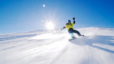 Kız yamaçlarda kayak yapıyor. Güneş ışınları ve alevler görünür..