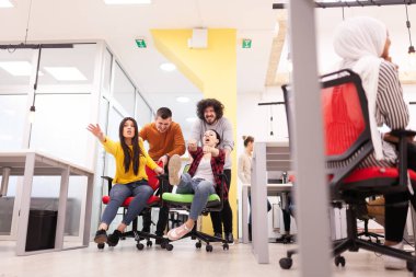 İş arkadaşları iş yerinde eğleniyorlardı. Tekerlekli sandalyedeki erkekleri iten kızlar. Çok ırklı başarılı bir şirket kurma grubu