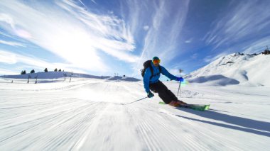 İsviçre Alplerinde kameraya doğru kayak yapan profesyonel bir kayakçı.