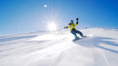 Kız yamaçlarda kayak yapıyor. Güneş ışınları ve alevler görünür..