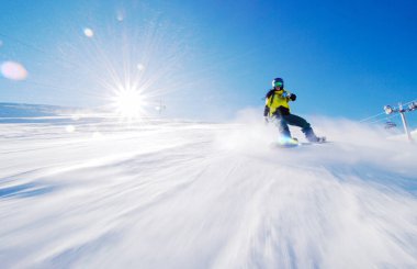 Kız yamaçlarda kayak yapıyor. Güneş ışınları ve alevler görünür..