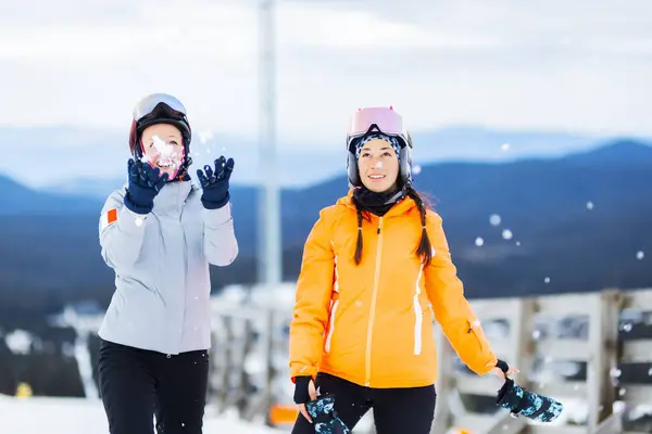 Two beautiful ski girls posing outdoors. Skier friends having fun.