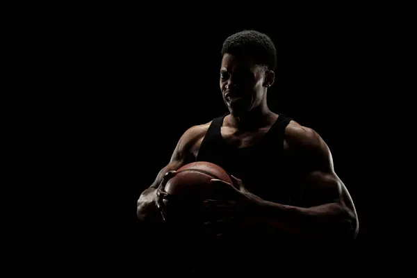 黒い背景に対してボールを保持するバスケットボールプレーヤー アフリカ系アメリカ人 シルエット — ストック写真