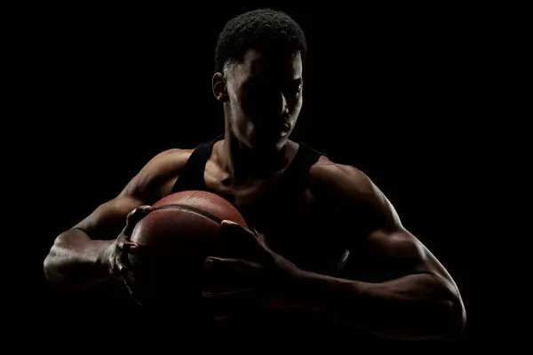 バスケットボール選手は黒を背景にボールを持っている 深刻な集中アフリカ系アメリカ人男性 — ストック写真