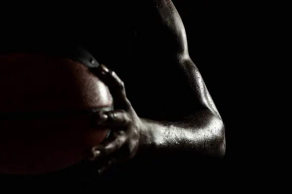 黒い背景に対してボールを保持するバスケットボールプレーヤー アフリカ系アメリカ人の男性の抽象的なぬれた男性の体 筋肉人 サイドレッドシルエット — ストック写真