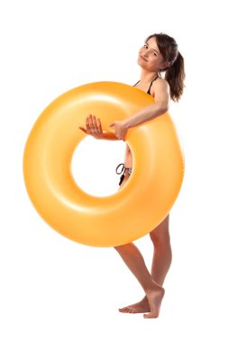 Siyah mayo giymiş, elinde turuncu şişirilebilir lastik yüzük tutan güzel, genç ve seksi bir kadın beyaz arka planda izole edilmiş. Yaz havuzu tatil köyü konsepti.