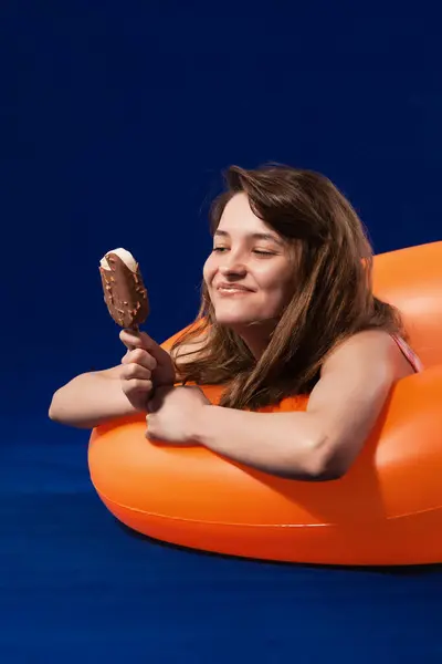Happy Girl Inflatable Orange Rubber Ring Enjoyng Chocolate Ice Cream — Stock Photo, Image