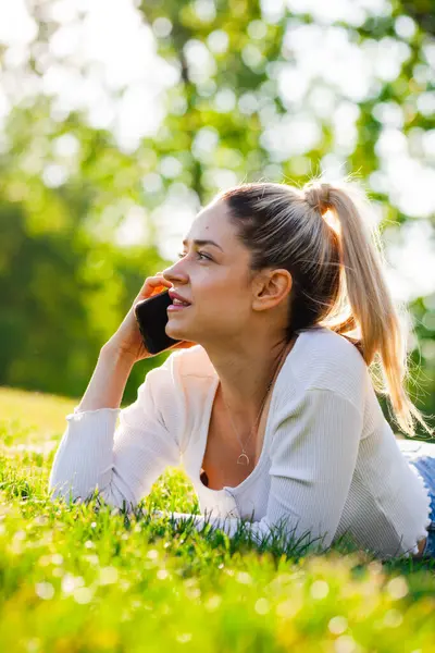 Gyönyörű Lány Fekszik Egy Mezőn Parkban Telefonon Beszél Stock Kép
