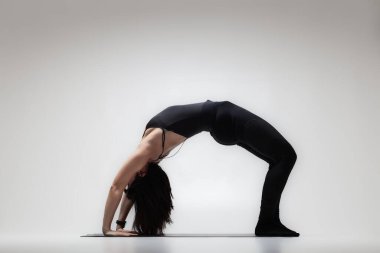 Yoga pozu veren beyaz güzel bir kadın. Esneme egzersizleri yapan bir kızın yarı silüeti..