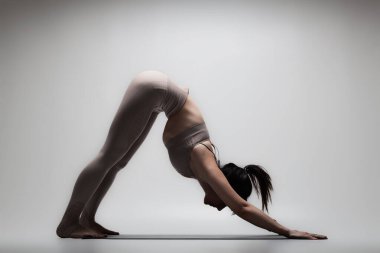 Yoga pozu veren beyaz güzel bir kadın. Esneme egzersizleri yapan bir kızın yarı silüeti..