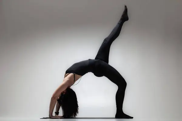 穿着瑜伽姿势的美丽的高加索女人 一个女孩做伸展运动的半影像 免版税图库照片