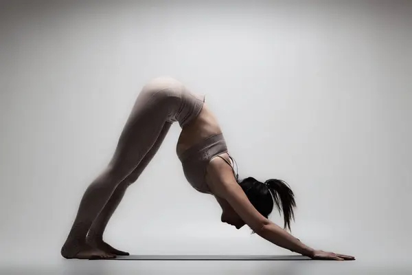 穿着瑜伽姿势的美丽的高加索女人 一个女孩做伸展运动的半影像 免版税图库照片