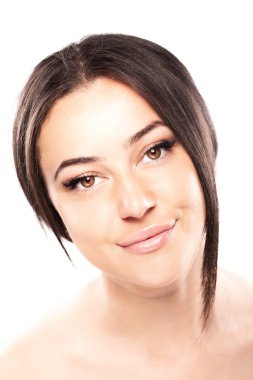 Güzel esmer bir kızın portresi beyaz arka planda izole edilmiş kameraya bakıyor..