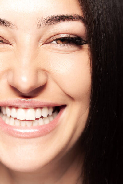 Закройте женский портрет. Женщина с открытым улыбающимся ртом, показывающая зубы. Девушка, глядящая в камеру.