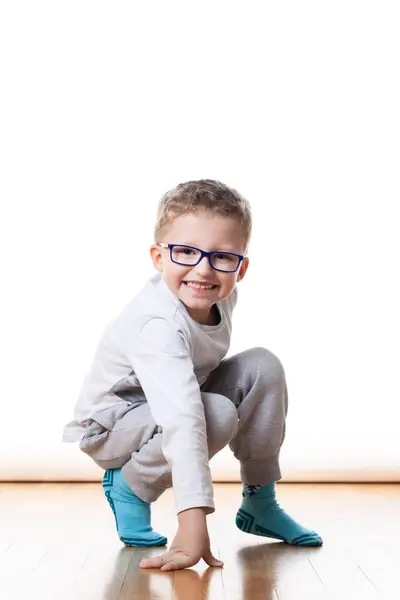 Ein Kleiner Junge Mit Brille Krabbelt Auf Dem Boden Stockfoto
