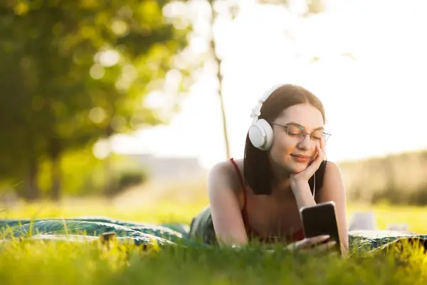 Gyönyörű Sötét Hajú Lány Zenét Hallgat Egy Fejhallgatóval Okostelefonjáról Egy Stock Fotó