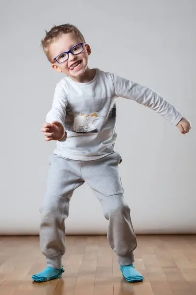 一个戴着眼镜和白衬衫的小男孩正在看着摄像机 玩得很开心 图库图片