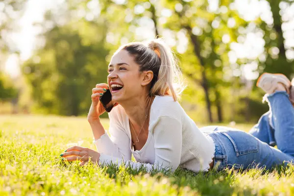 Schöne Mädchen Liegt Einem Feld Park Telefonieren lizenzfreie Stockfotos