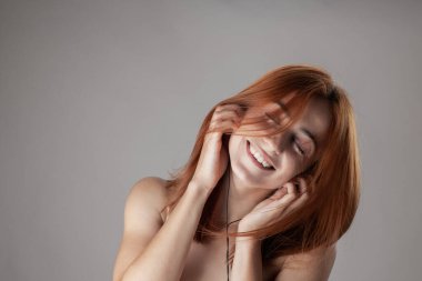 Canlı bir görüntü, müziğin içinde kaybolmuş mutlu, genç bir kızıl kadını çekiyor. Gözleri kapalı gülümsüyor, elleri saçlarında..