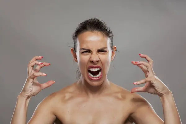 stock image Portrait of an angry young woman screaming in frustration, showing extreme emotion and facial expression in a studio setting.