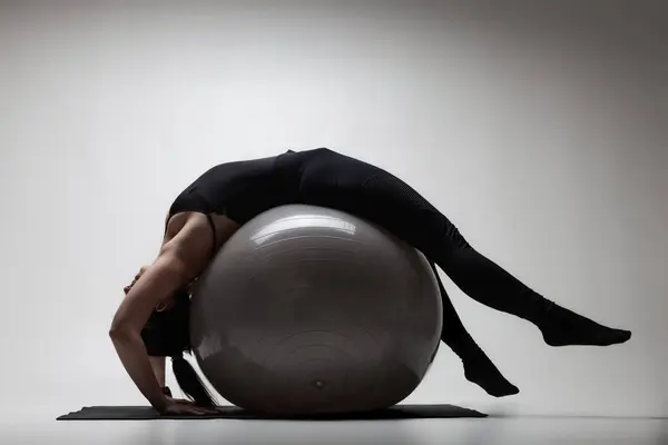 Young Woman Demonstrates Flexibility Balance Yoga Pose Large Grey Fitness Stockfoto