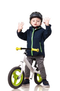 Evde dengeli bisiklet süren kask takan sevimli bir çocuk. Çocukluğa, güvenliğe ve ata binmeyi öğrenmeye odaklan..
