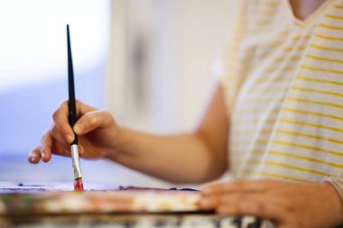 Sanatsal bir tabloda fırça kullanan bir el. Sanat yaratan kadın sanatçı..