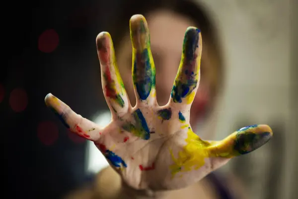 stock image Vibrant photo of a female artist's hand covered in multi-colored paint, emphasizing artistic flair and the joy of painting.