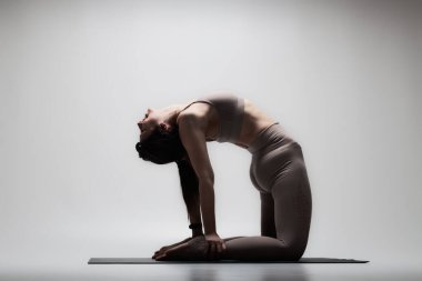 Yoga pozu veren beyaz güzel bir kadın. Esneme egzersizleri yapan bir kızın yarı silüeti..