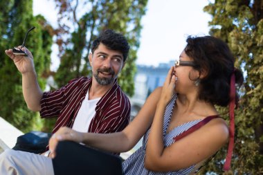 Neşeli bir erkek ve kadın, neşeli ve samimi bir anı paylaşır. Canlı yeşillikleriyle, gerçek bir bağ ve kahkaha gösterirler..