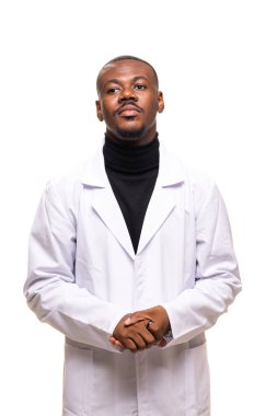 Beyaz önlüklü, kendine güvenen bir birey, elleri sımsıkı bağlanmış, profesyonellik ve uzmanlık yayıyor, tarafsız bir arkaplana karşı duruyor, tıbbi ya da bilimsel alanda kendini adamış..