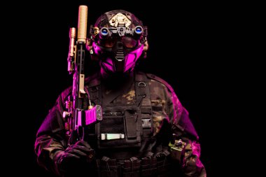 Yüksek teknoloji teçhizatlı ve zırhlı ağır donanımlı bir asker dramatik pembe ışık altında poz verdi. Fütüristik stilde gelişmiş teknoloji ve askeri teçhizat vurgulanıyor.