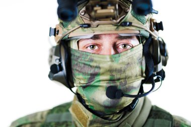 Operasyonlar sırasında iletişim ve kamuflaj amaçlı tasarlanmış miğfer ve yüz maskesi de dahil olmak üzere ileri taktik teçhizat giyen bir askeri askerin yakın çekimi, profesyonel askeri teçhizat ve hazırlık.